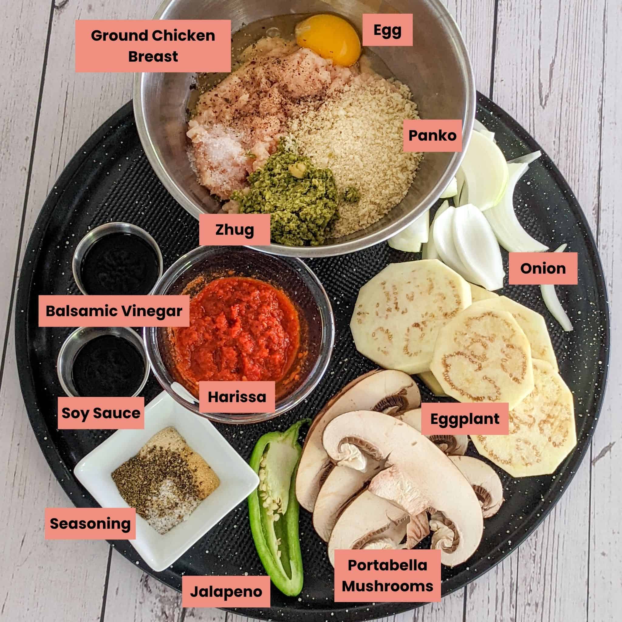 labeled ingredients for the Harissa Chicken Burger recipe on a round sheet tray.