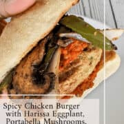 Spicy chicken burger topped with harissa eggplant, portobello mushrooms, and onions on a toasted bun.