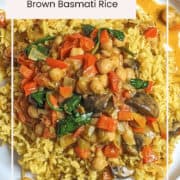 Curried chickpeas and mushrooms on spiced brown basmati rice, vibrant and flavorful vegetarian dish.