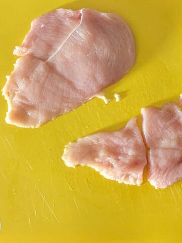 a butterflied chicken that has been divided into two with one half cut into thirds for small chicken cutlets