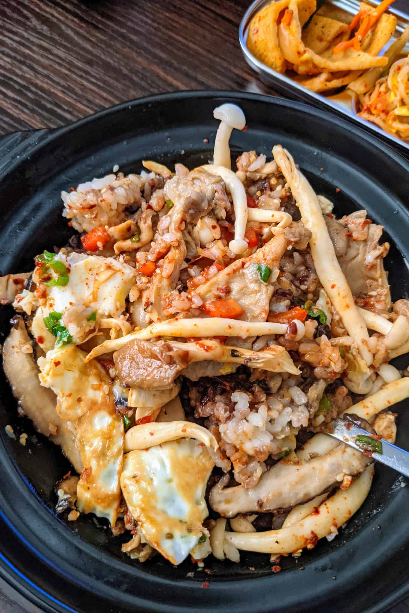 Delicious mushroom and rice, korean bibimbap with spicy sauce and green onions for a healthy meal.