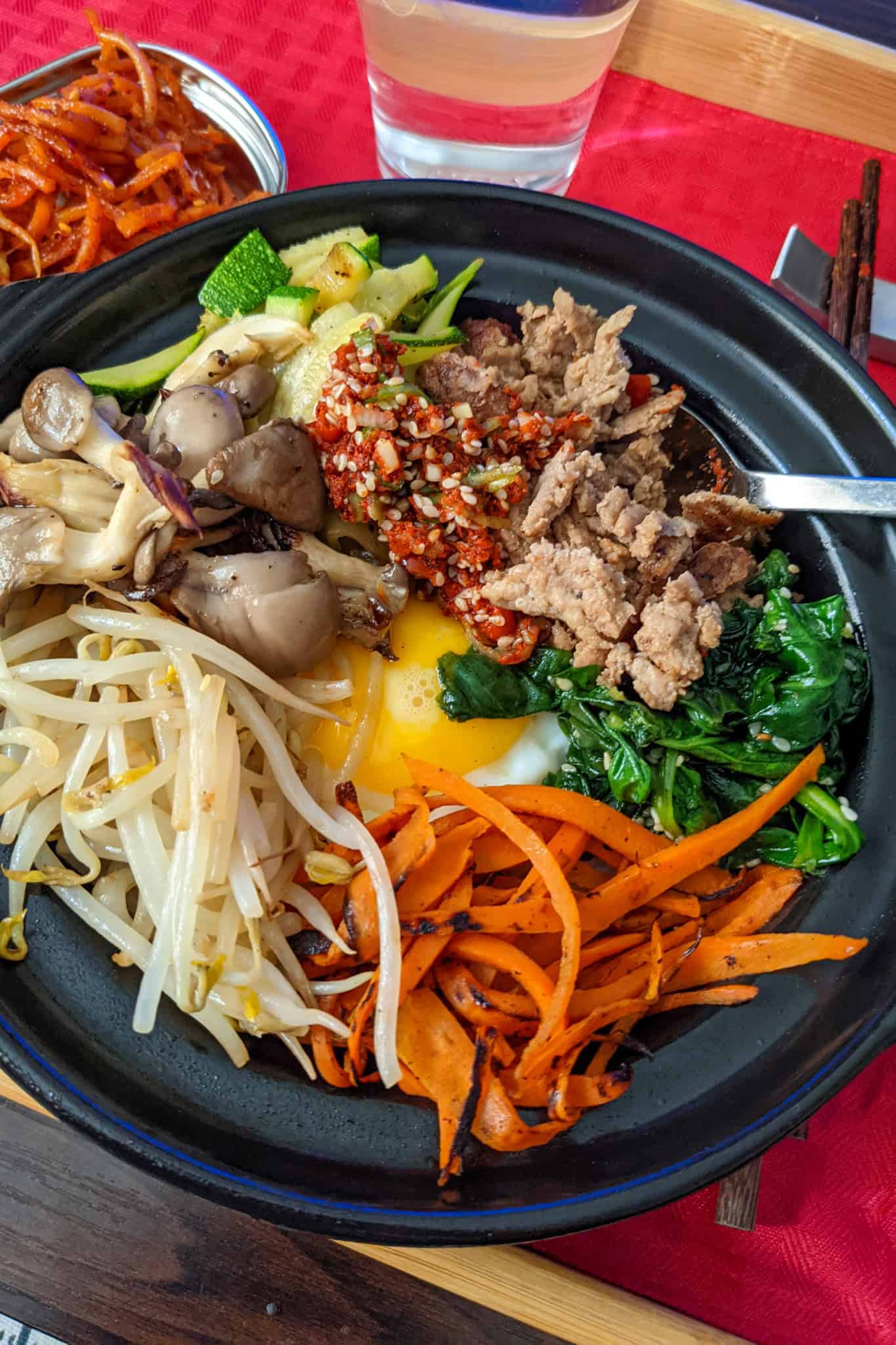 korean mushroom bibimbap with vegetables in a stone bowl.