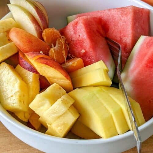 bowl with watermelon, mango, peach. pineapple and apple slices