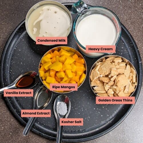 ingredients for the mango cookies and cream no churn ice cream on a round tray.