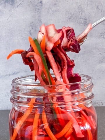 Pickled Vegetables in a Jar Picked out with Fork