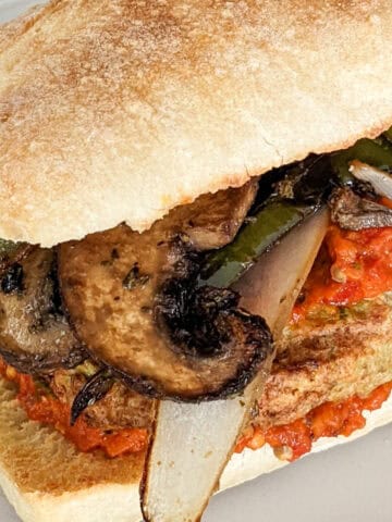 upclose of the spicy chicken burger with harissa, eggplant, portabella mushrooms, and onions