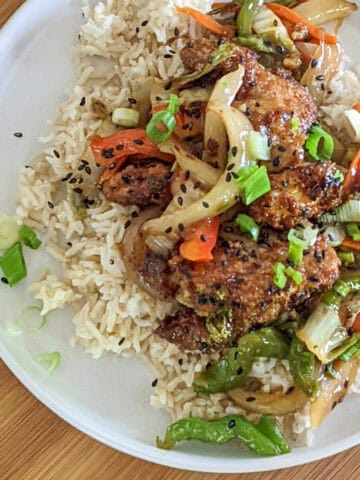 sesame chicken stir-fry on rice on plate