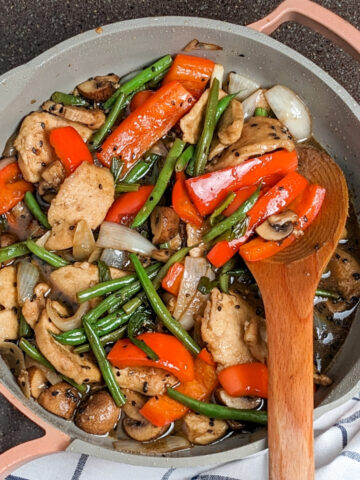 chicken, green beans, onions, red bell peppers and mushrooms in a pan with hoisin sauce