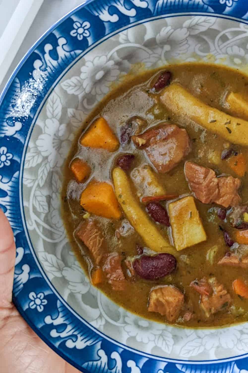 turkey red bean stew in a bowl held in hand