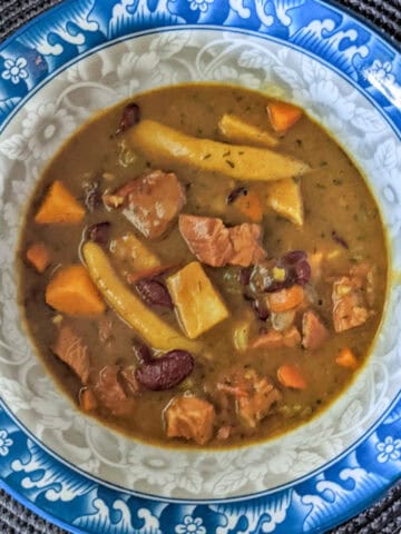 turkey red bean stew in a bowl held in hand