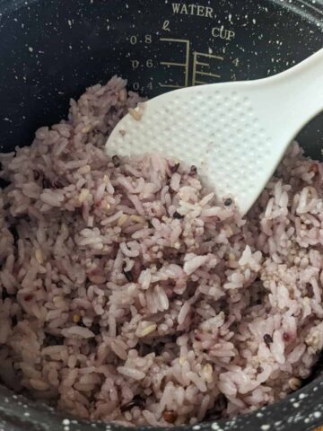 multigrain rice with a purple tint in a rice cooker canister