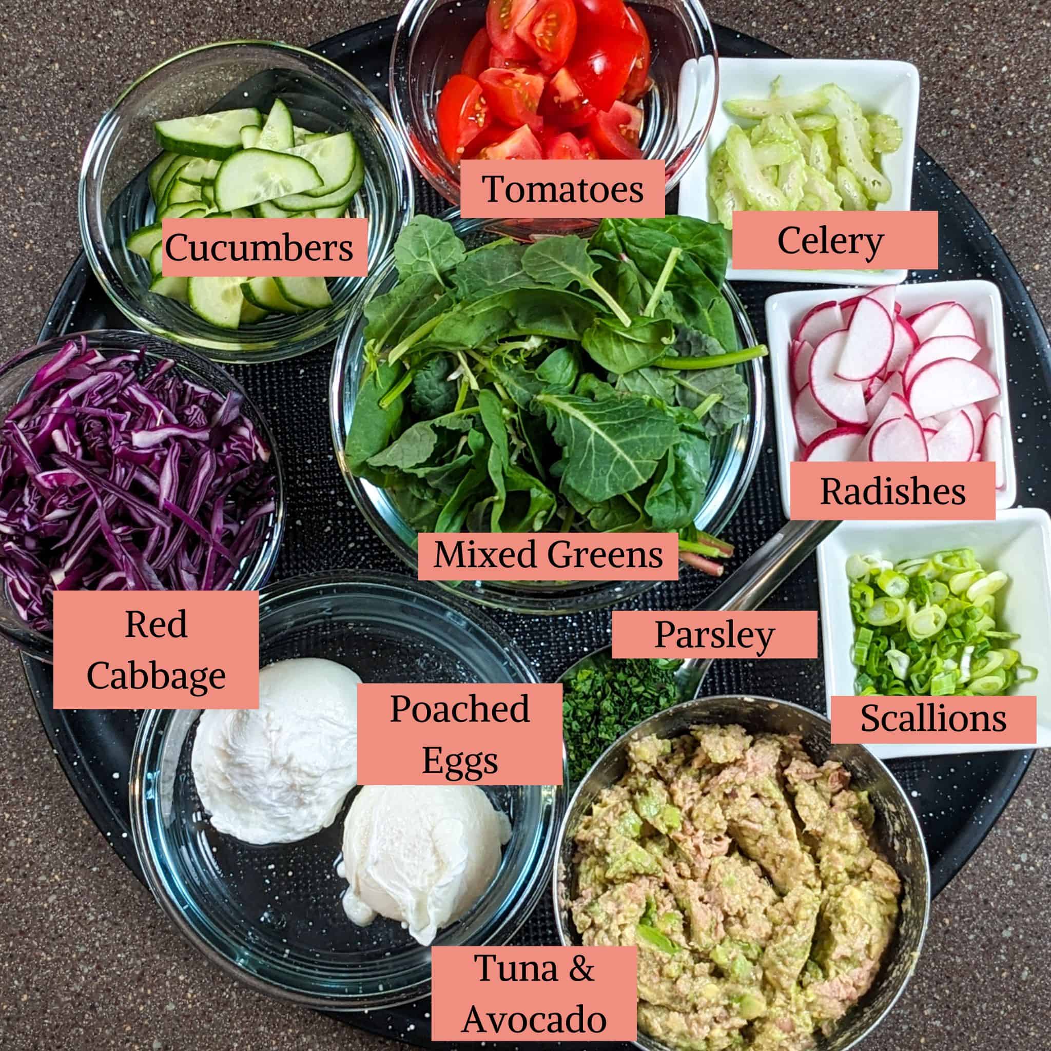 ingredients for the rainbow tuna salad in containers on a round black pizza pan