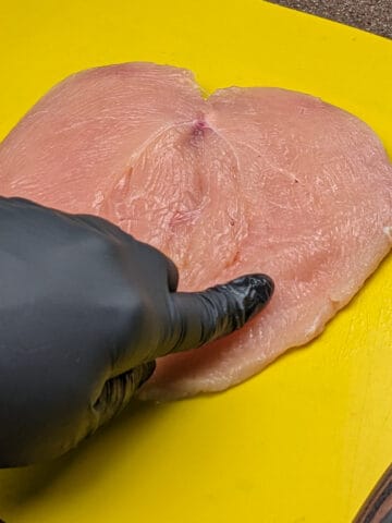 butterflied chicken breast on a cutting board.
