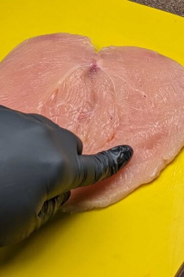 butterflied chicken breast on a cutting board.