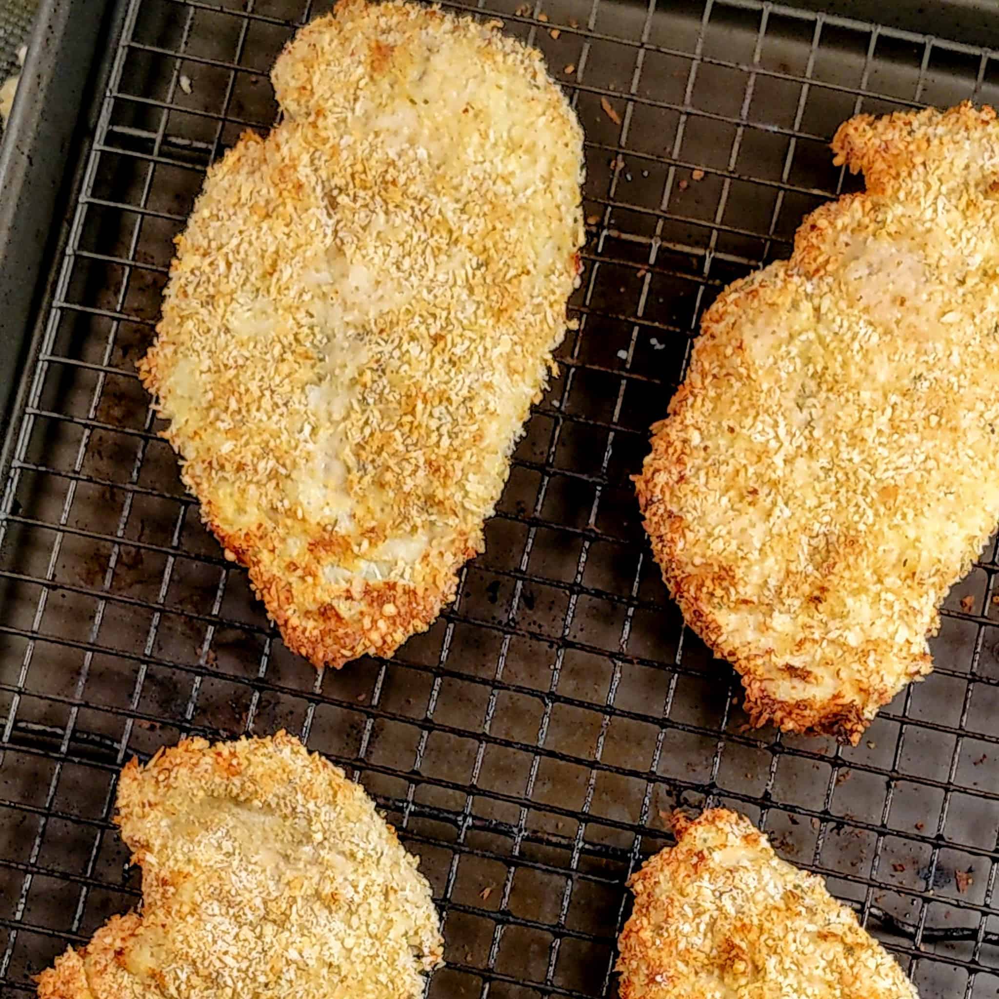 golden brown panko breaded chicken cutlets on a sheet pan with a wire rack