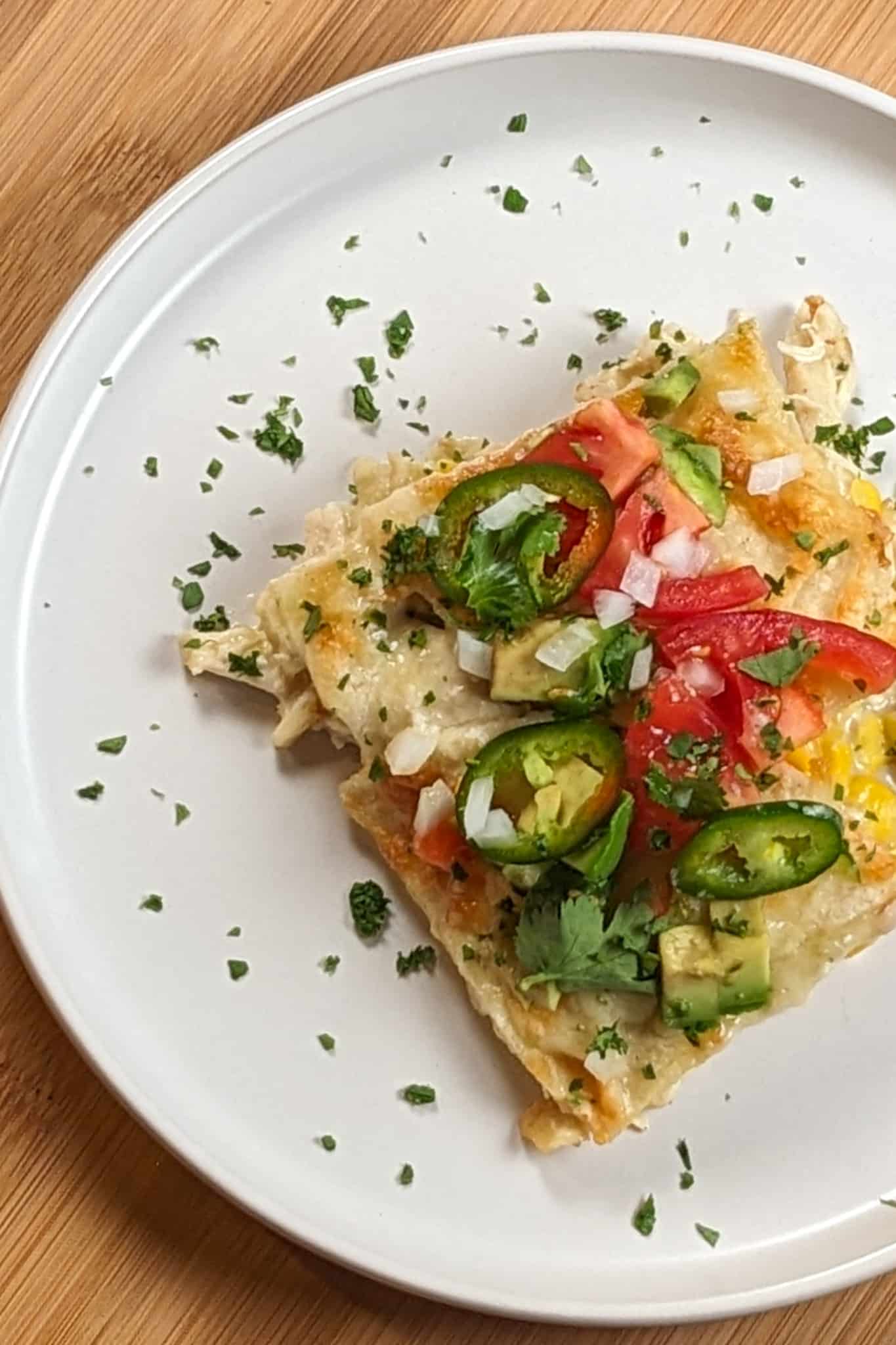 top view of the Chicken Tortilla Lasagna on a round place garnished with fresh chopped cilantro