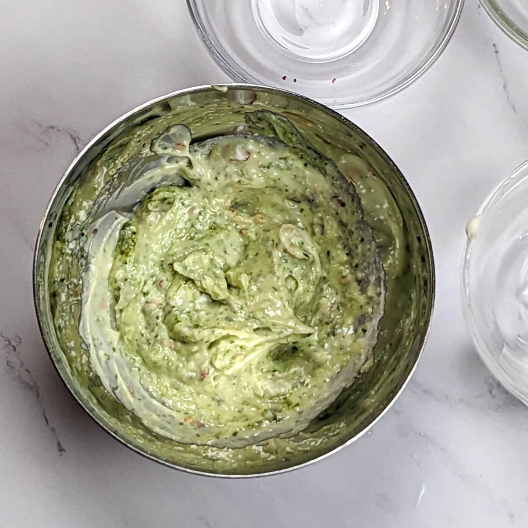 spicy basil pesto mayo in a bowl on a marble counter