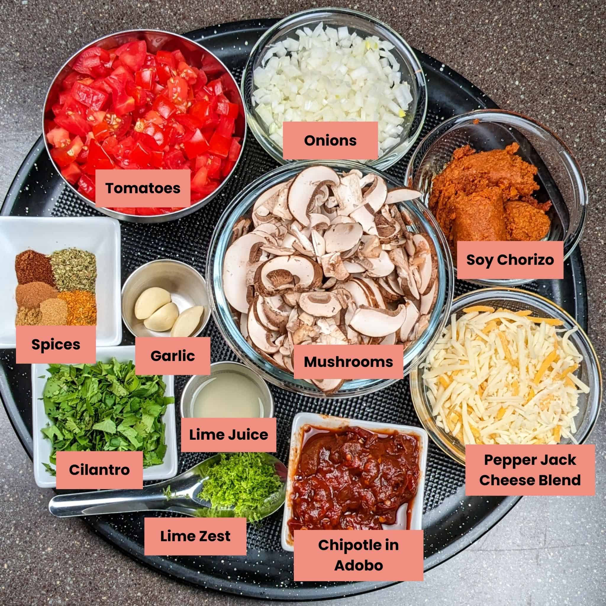 ingredients in containers on a large pizza pan for the vegetarian chipotle mushroom lentil bean chili