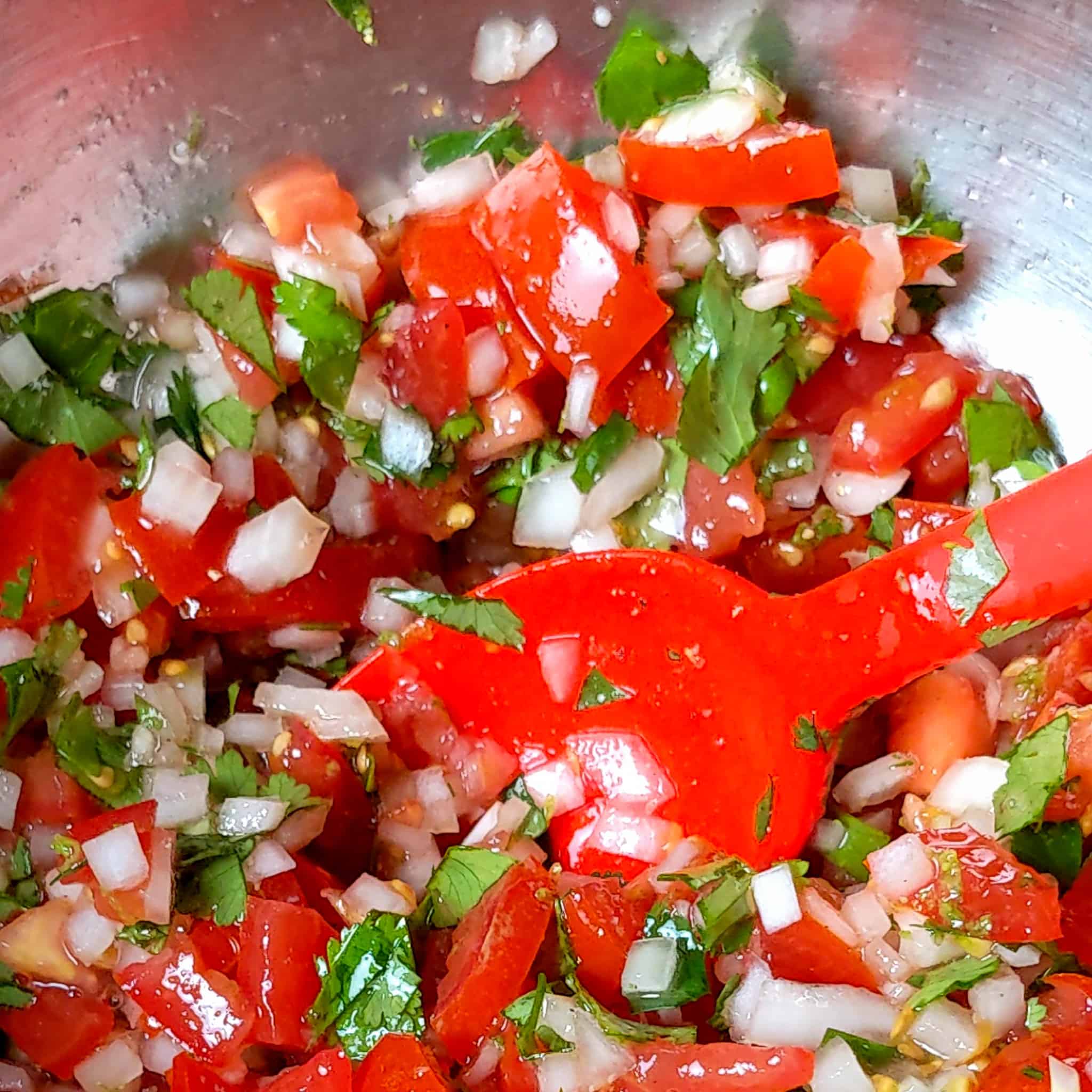 pico de gallo without lime juice and zest in a metal bowl with a silicone spoon