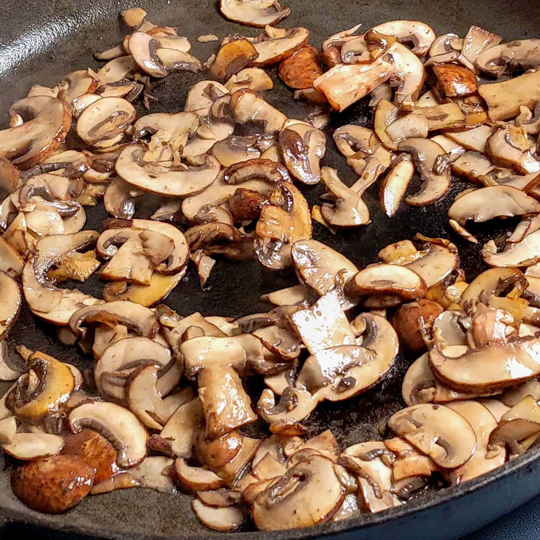 browned sliced mushrooms in a large wide cast iron skillet
