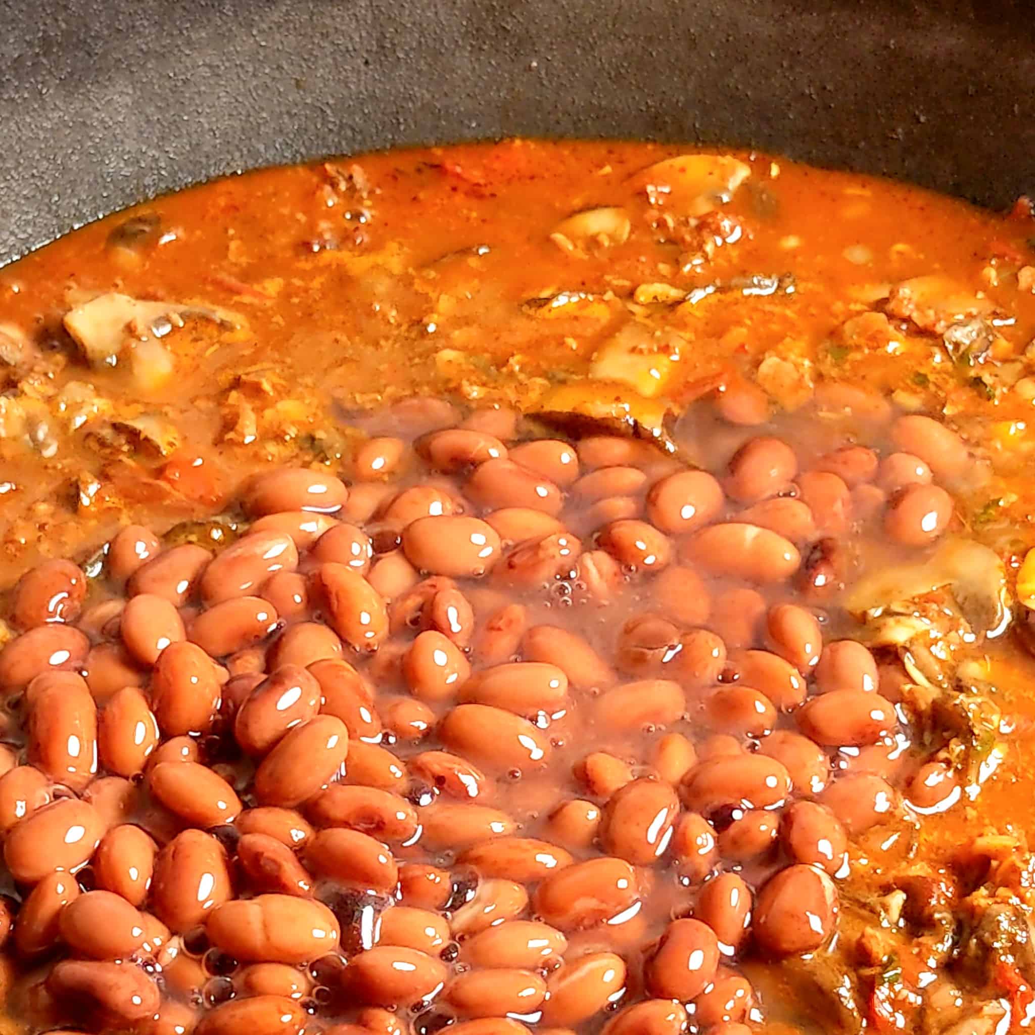 pinto beans added to the mushrooms and vegetables simmering in vegetable broth for the mushroom lentil bean chili