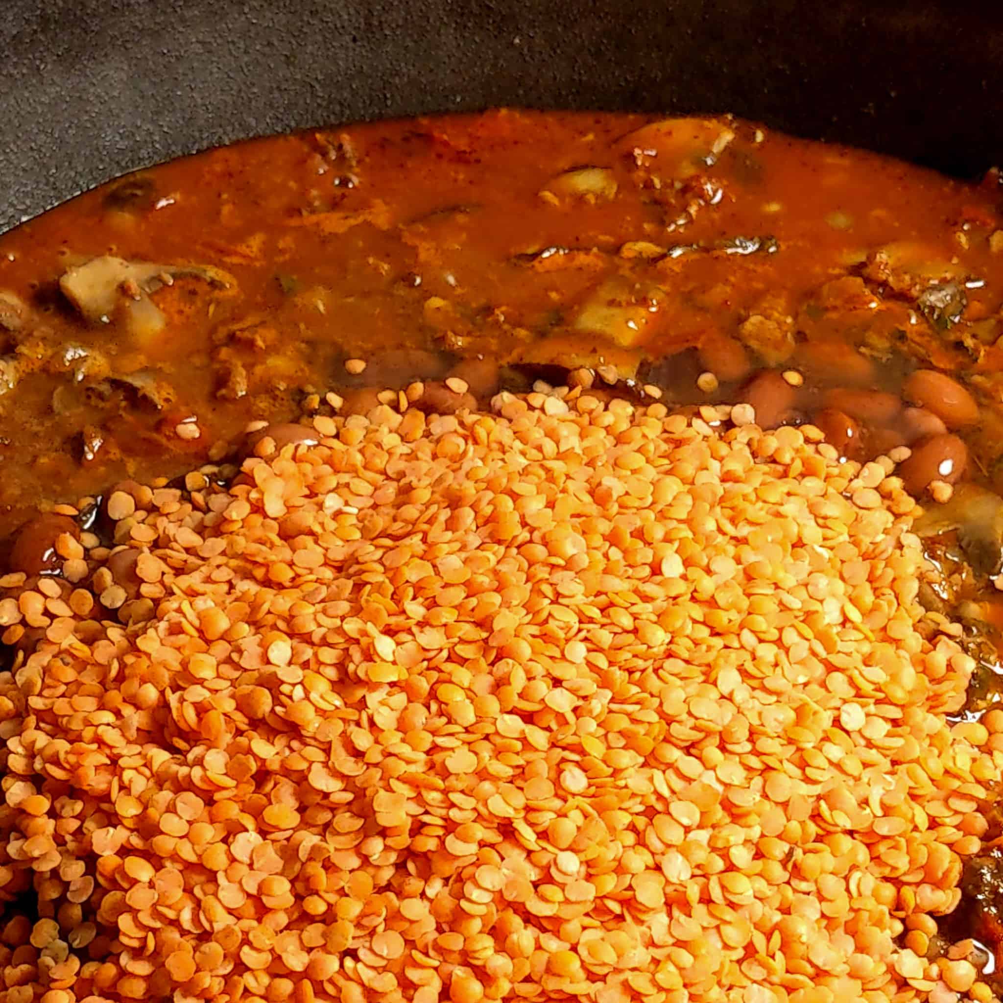 split red lentils added to the pinto beans, mushrooms and vegetables simmering in vegetable broth for the mushroom lentil bean chili