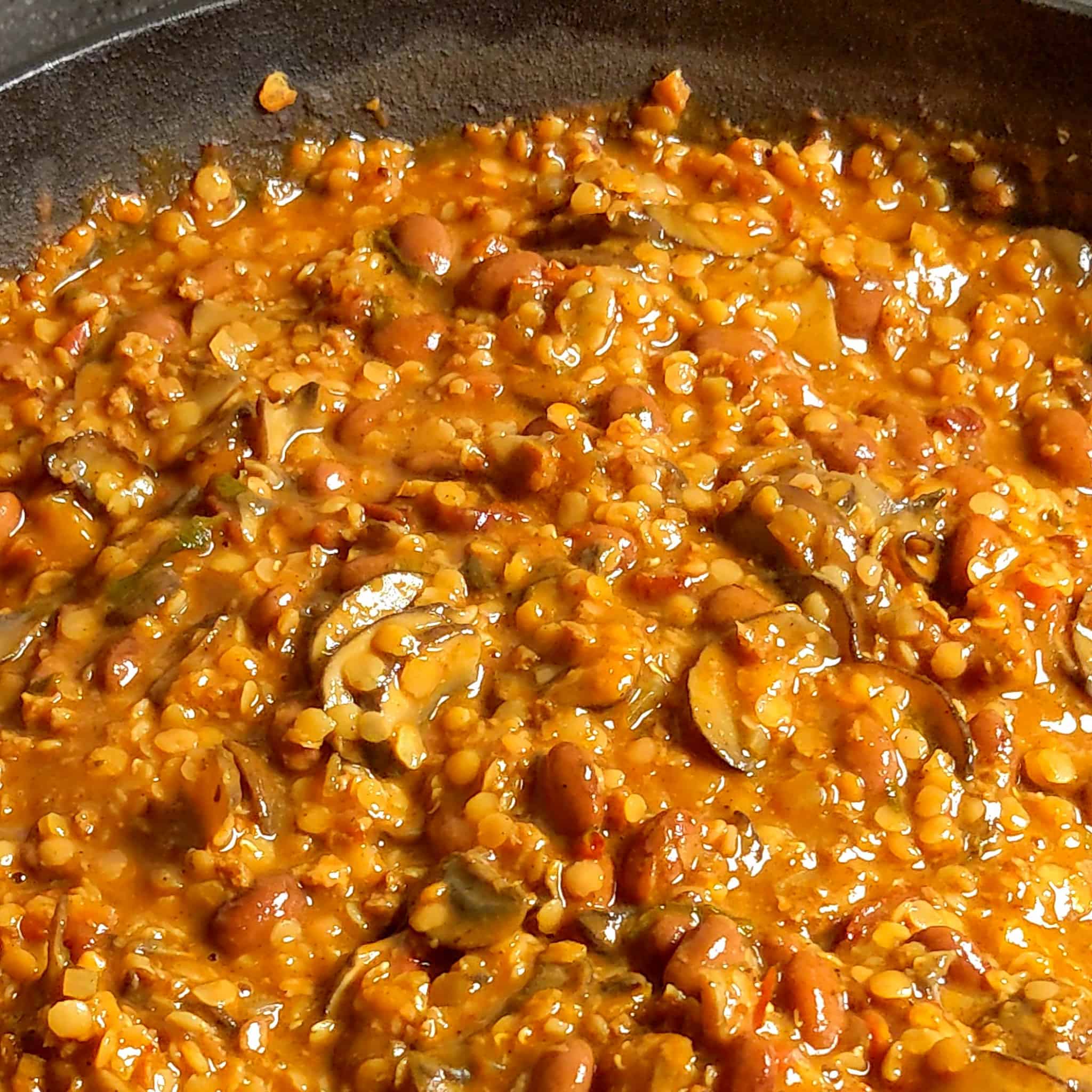 split red lentils, pinto beans, mushrooms and vegetables simmering in vegetable broth for the mushroom lentil bean chili