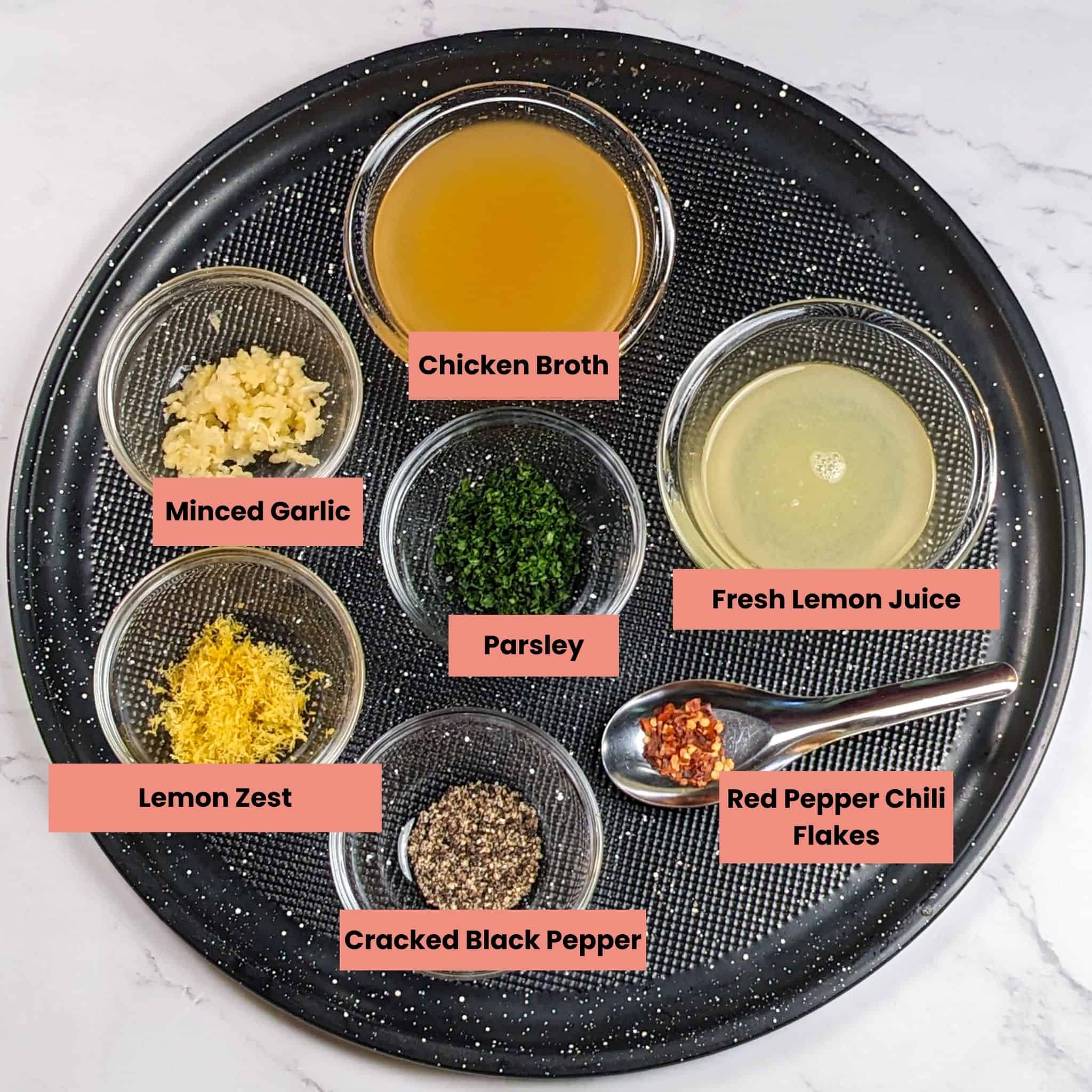 ingredients for the lemon pepper sauce in containers on a round large pizza tray