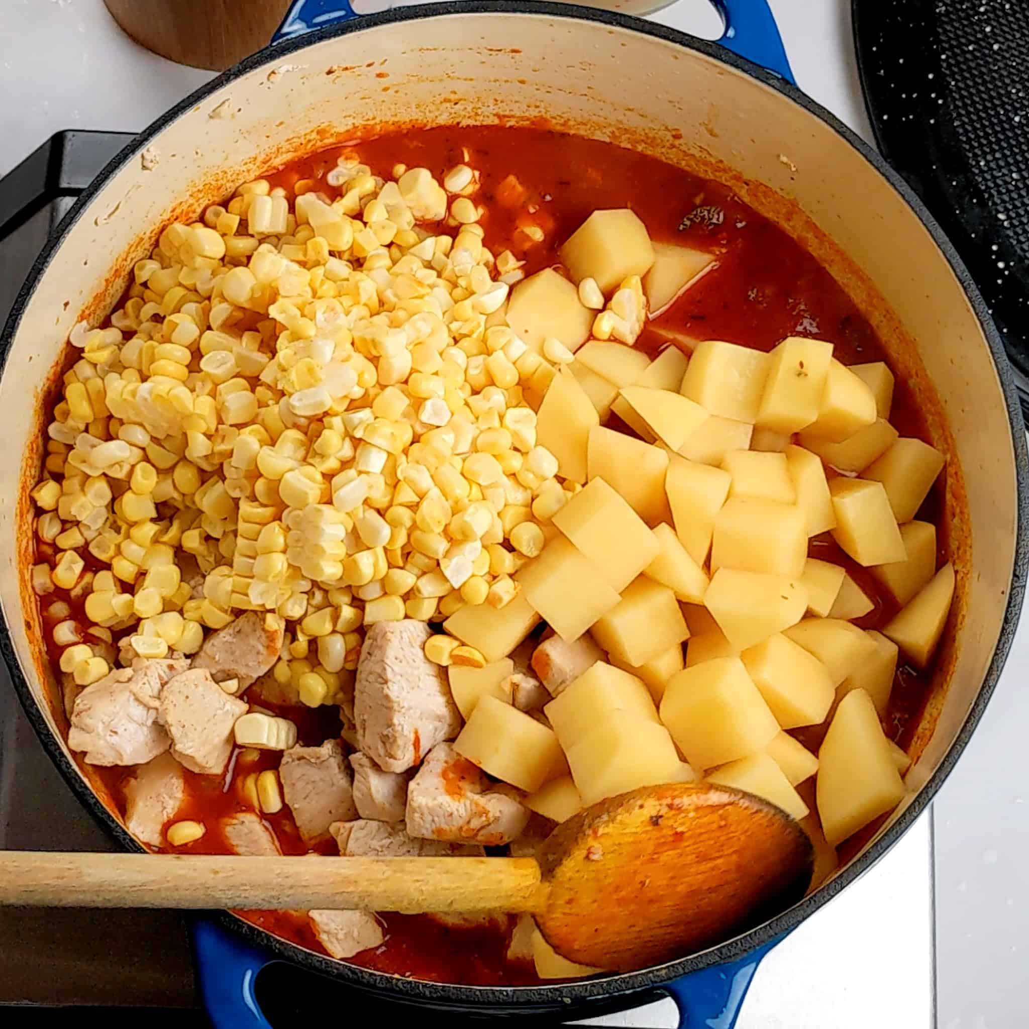 the tomato base topped with diced yukon gold potatoes, fresh corn kernels and diced chicken