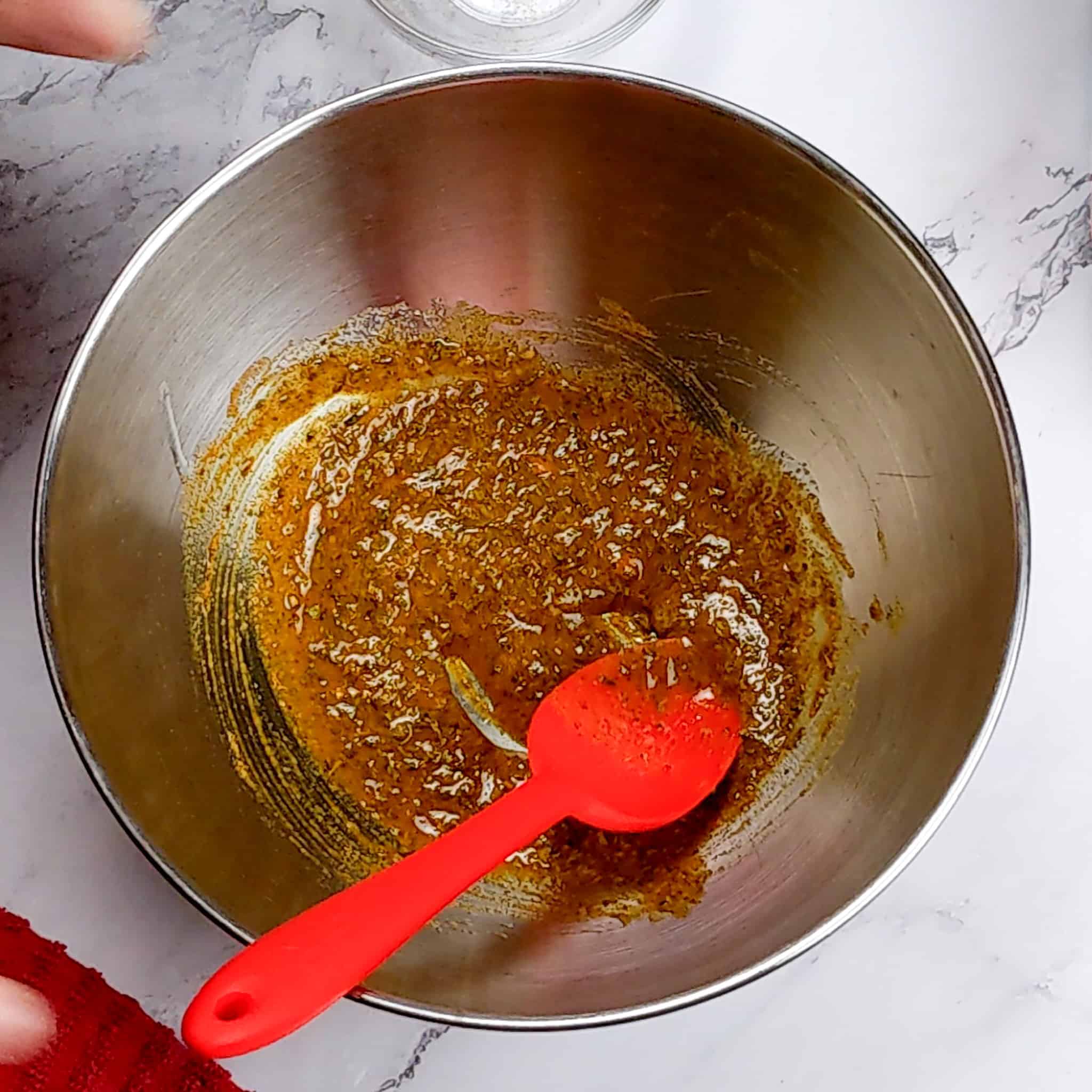 wet rub mixture in a stainless steel mixing bowl with a GIR silicon spoon