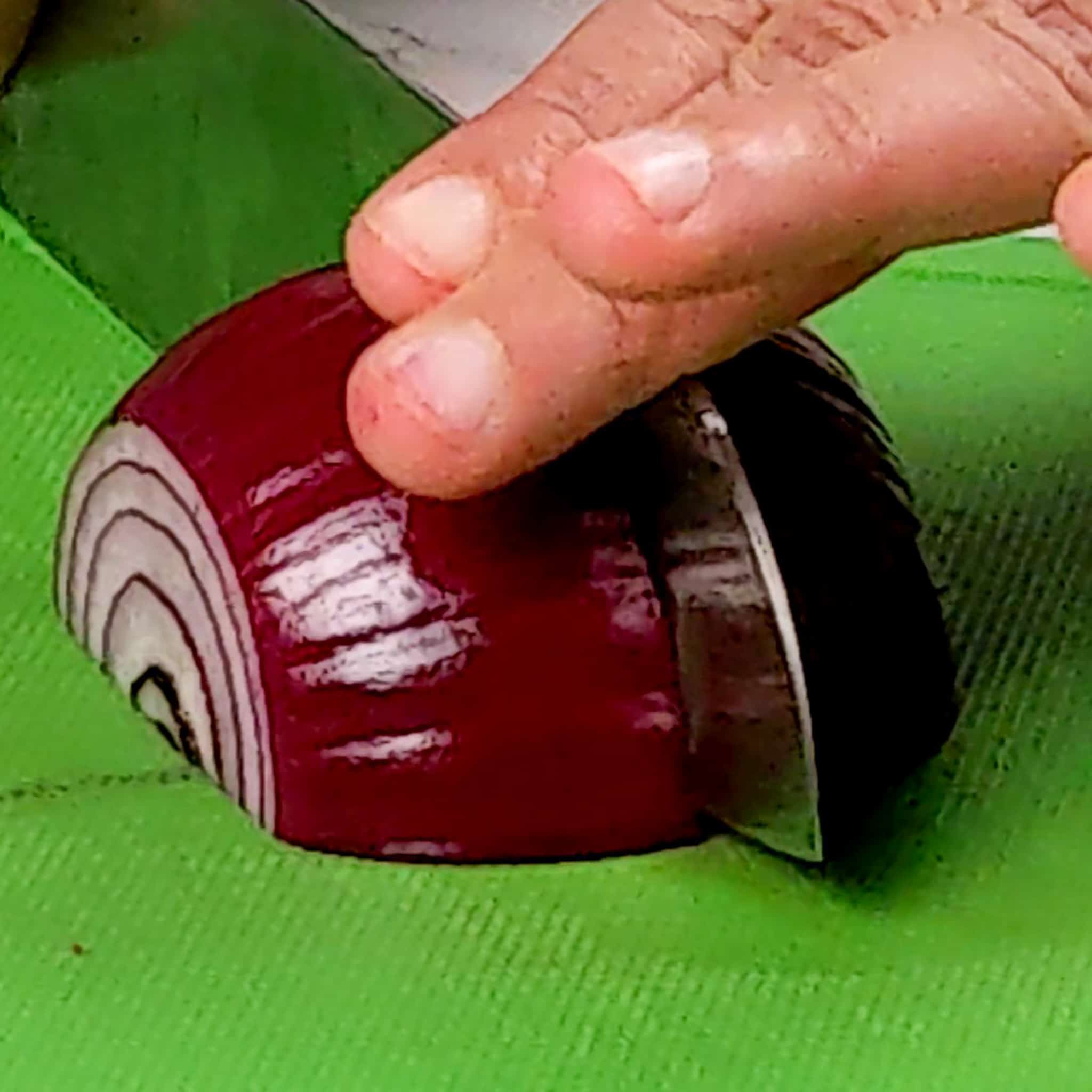 close up of cutting on a halved red onion