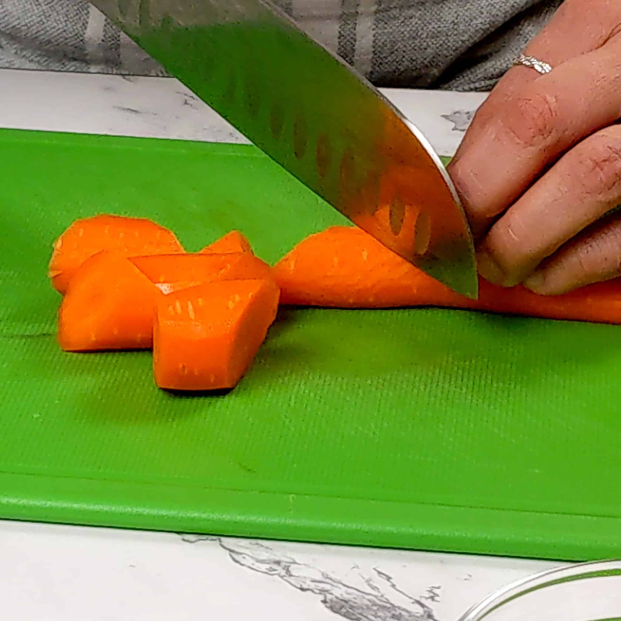 a carrot being cut into large slices on a diagonal