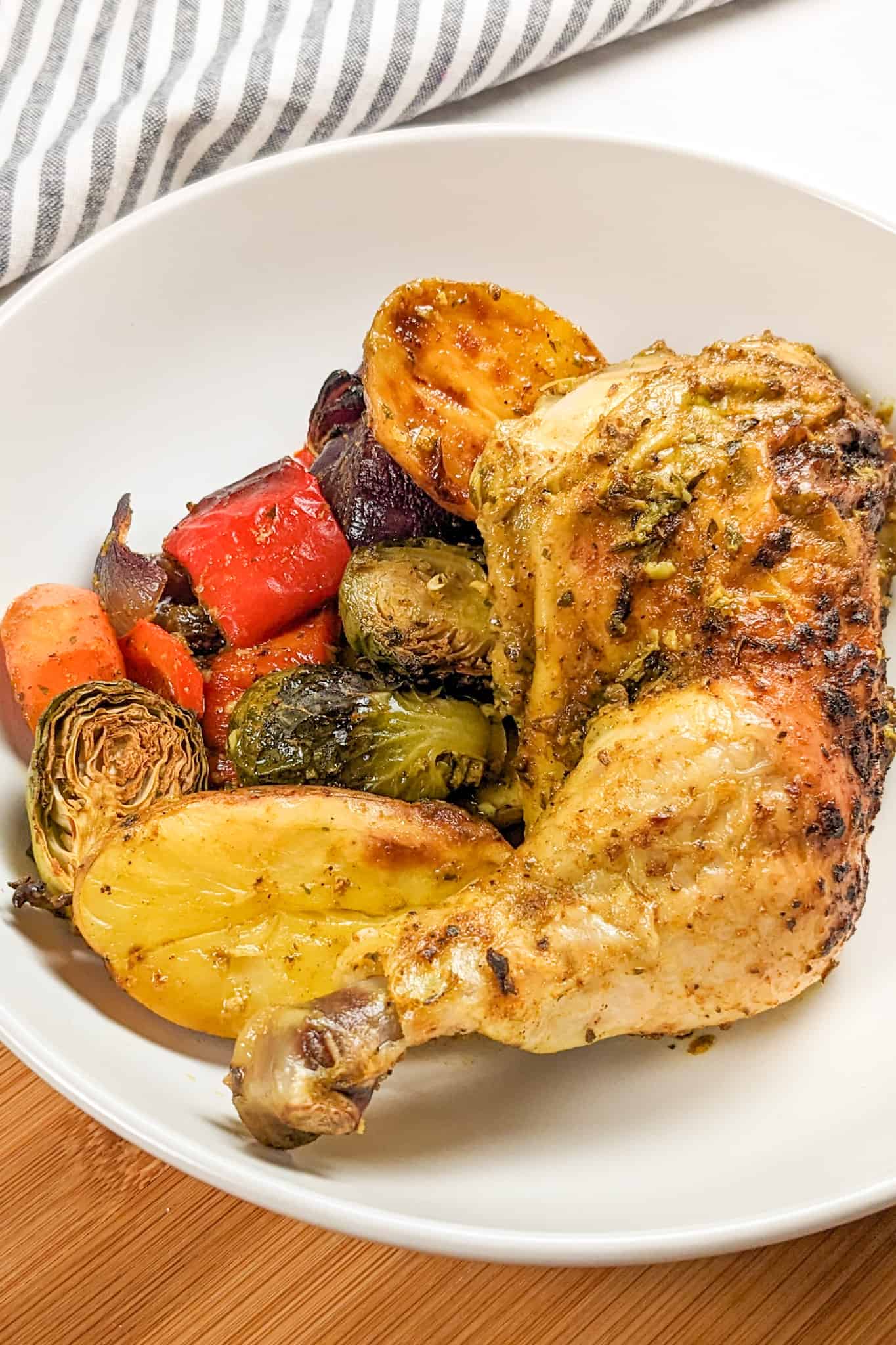 top side view of the Curry spatchcocked chicken with vegetables plated in a large wide round bowl