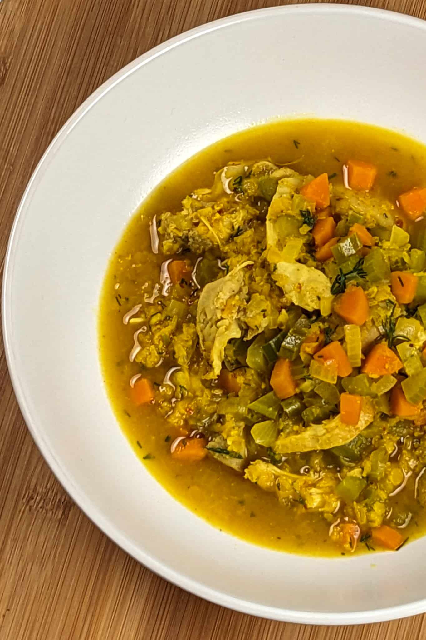 top view of the plated aleppo pepper spiced dill lentil chicken soup in a round wide bowl