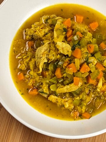 top view of the plated aleppo pepper spiced dill lentil chicken soup in a round wide bowl