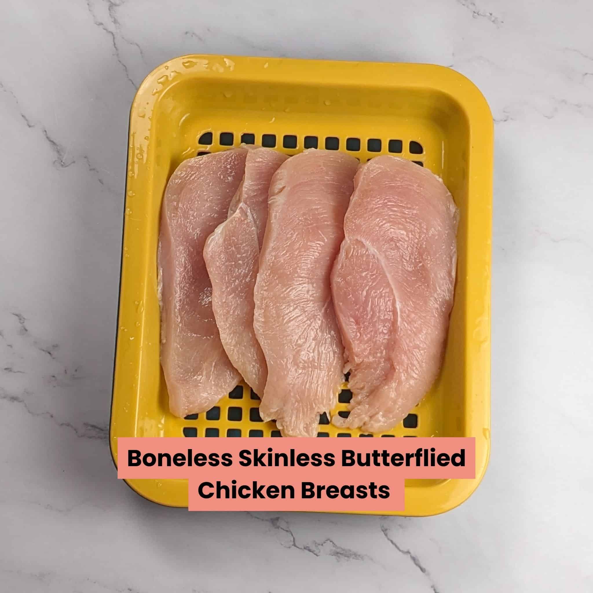 butterflied chicken breast in a draining container