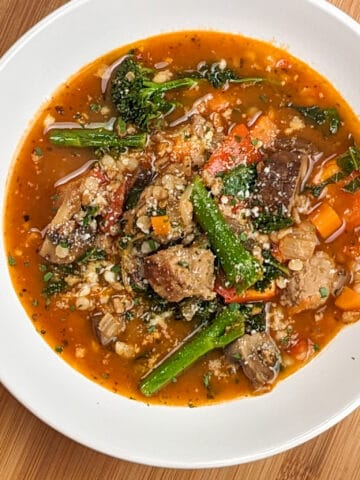 top view of the plated easy spicy italian chicken sausage soup with farro and israeli couscous