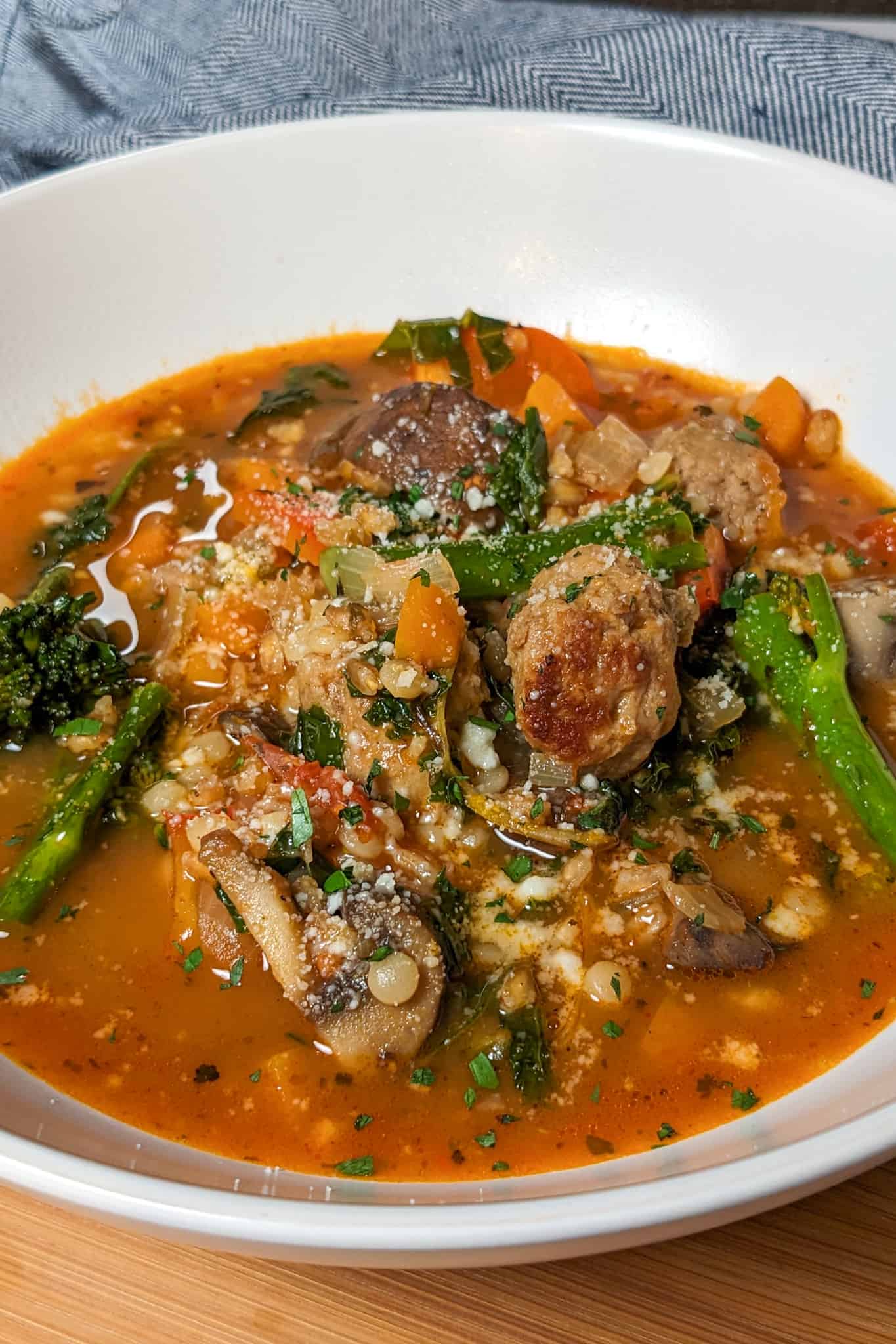 top side view of the plated easy spicy italian chicken sausage soup with farro and israeli couscous