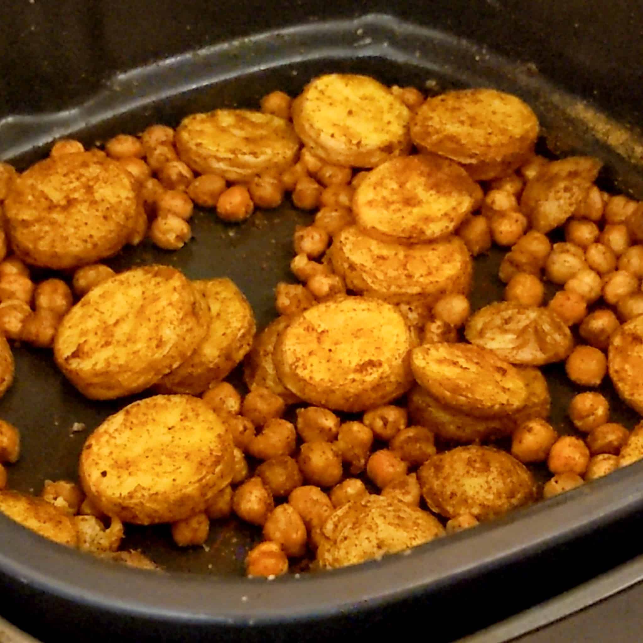 air fried roasted chickpeas and sliced baby Dutch yellow potatoes in an air fryer roasting pan attachment