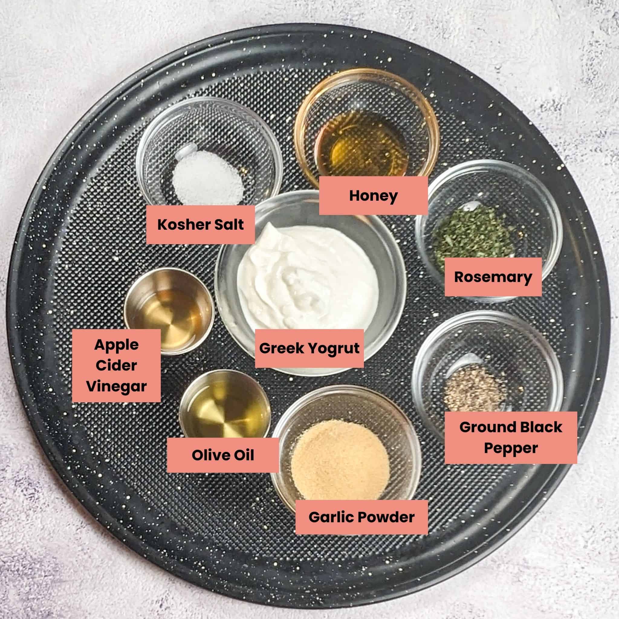 ingredients for the greek yogurt sauce in containers on a large pizza pan