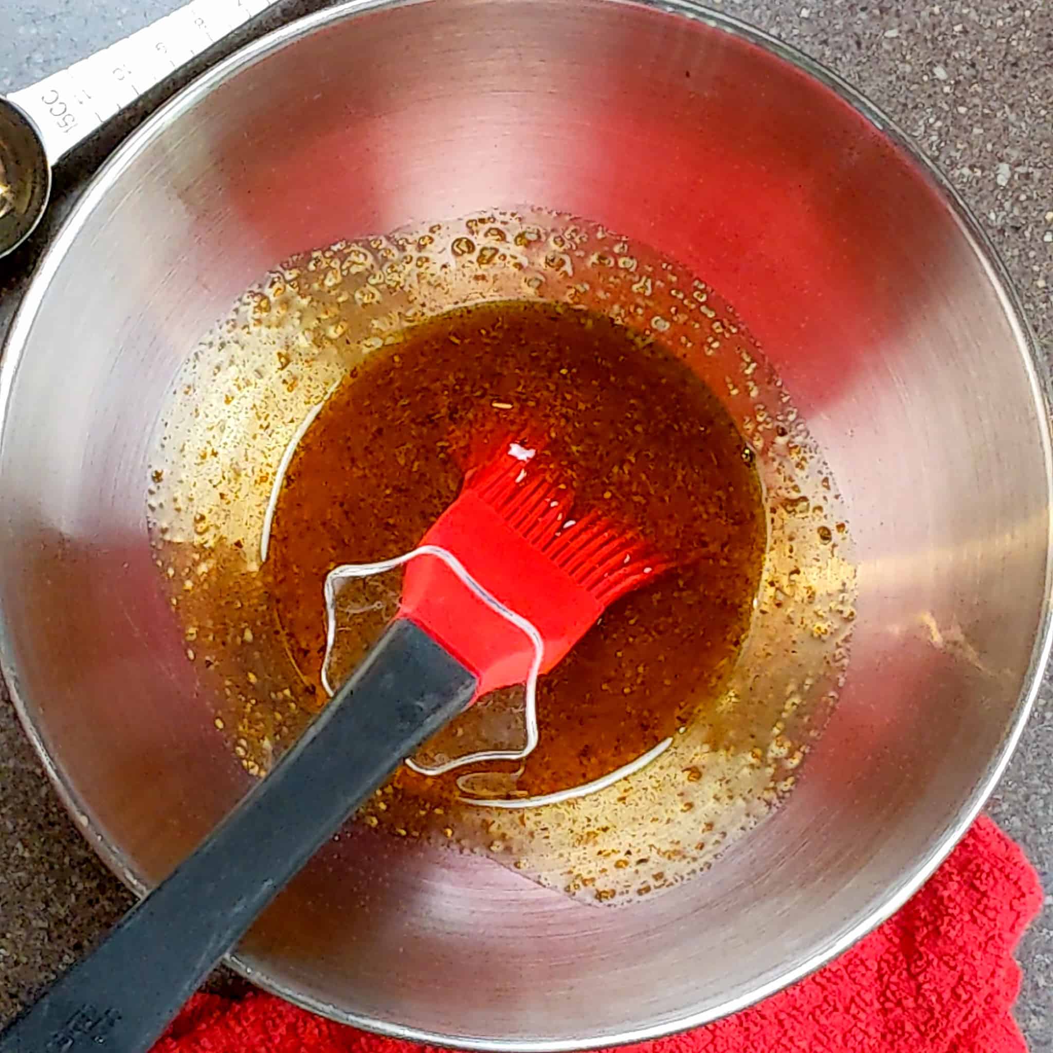 wet rub in a stainless steel mixing bowl with a silicone brush