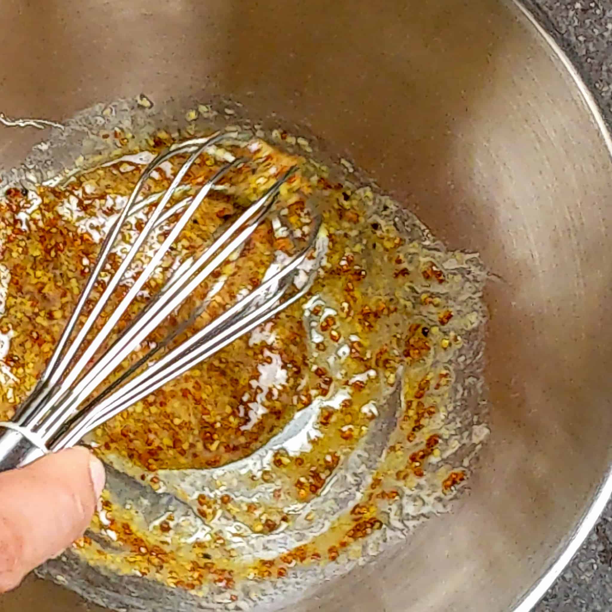 a bowl with the honey dijon mustard sauce being whisked
