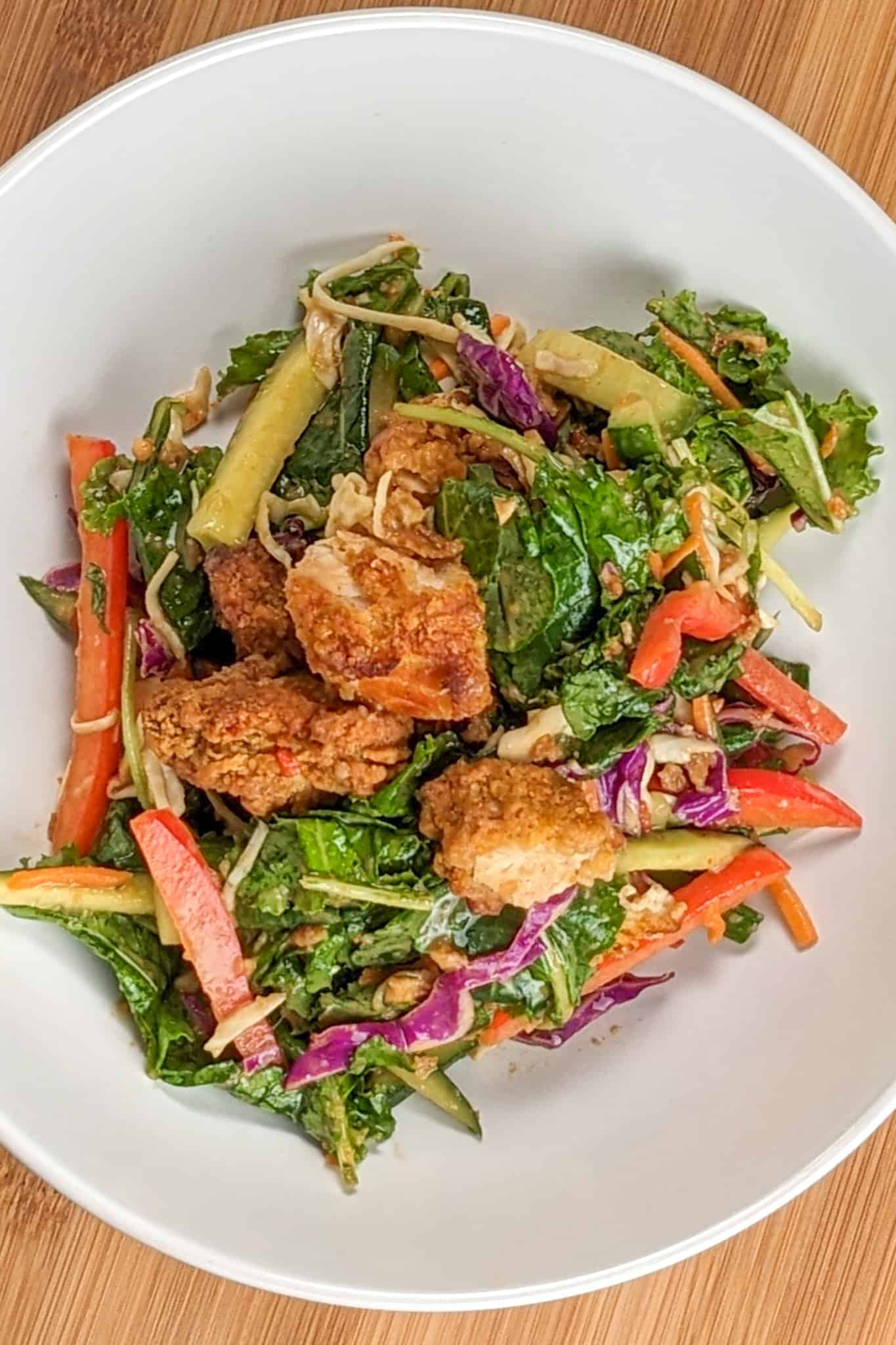 top view of the Sweet Chili Peanut Chicken Tenders Salad in a wide rim salad bowl