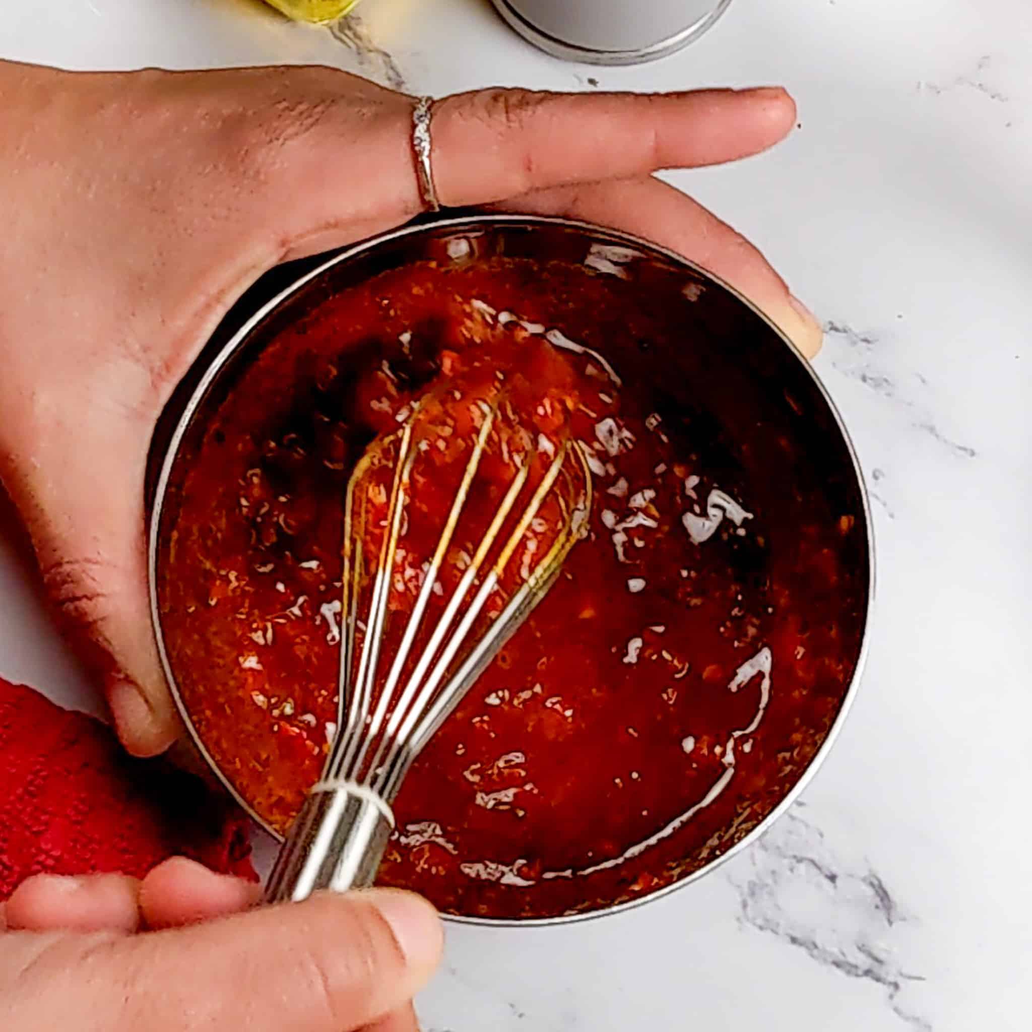 Calabrian pepper basil sauce being whisked together in a small stainless steel mixing bowl