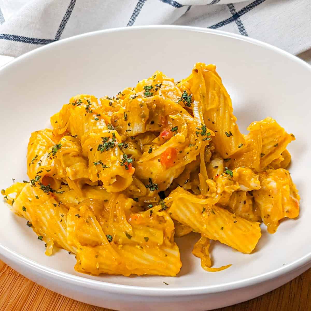 top view of the Creamy Cheesy Sage Chili Pumpkin Chicken Pasta in a round wide pasta bowl.