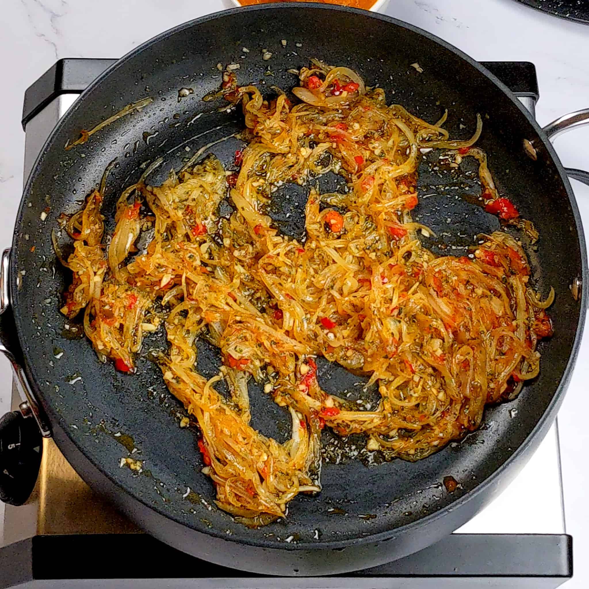 caramelized thinly sliced onion seasoned with chopped garlic, sage, and Calabrian peppers in a non-stick saute pan