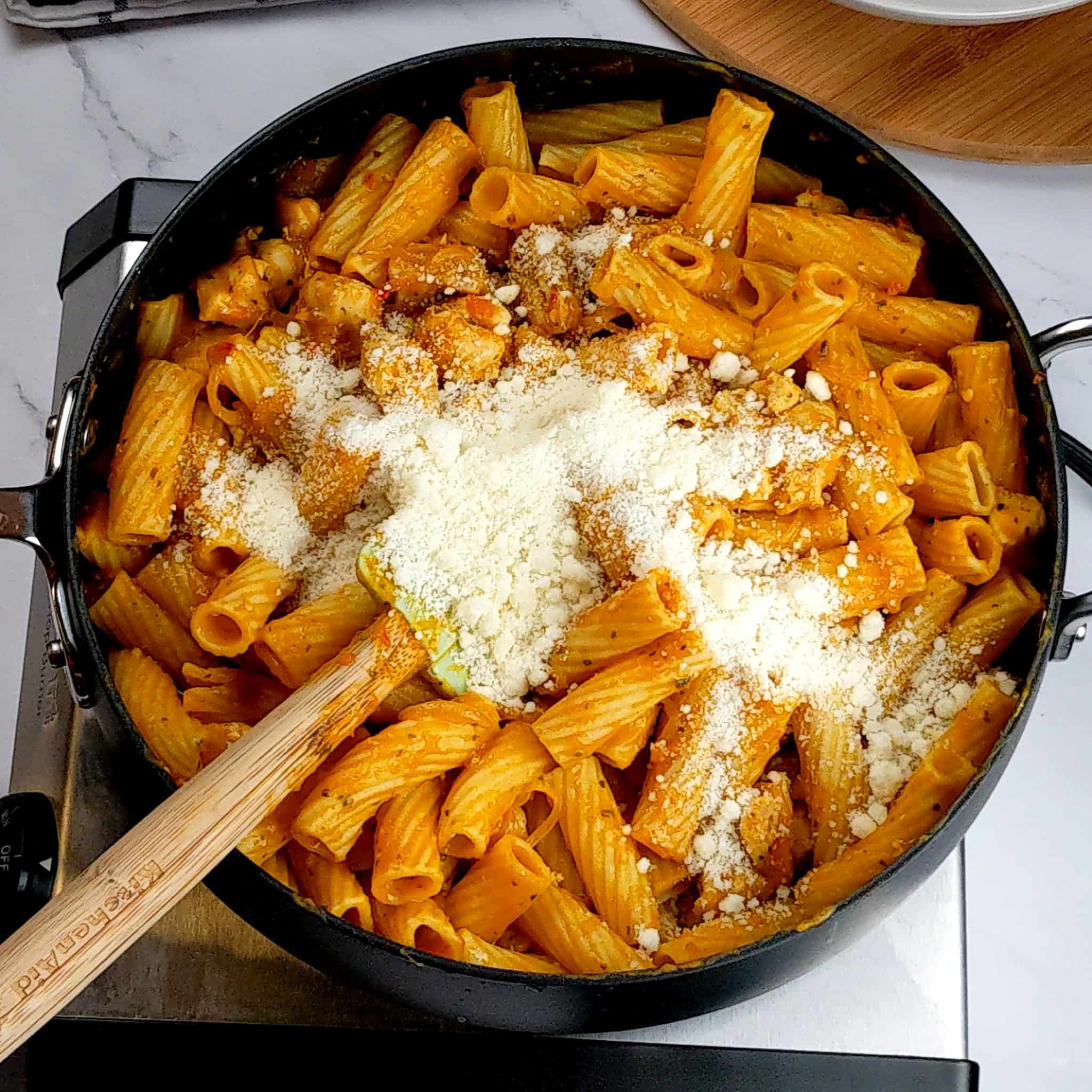 sage pumpkin chicken rigatoni pasta in a nonstick large saute pan with grated cheese poured on top