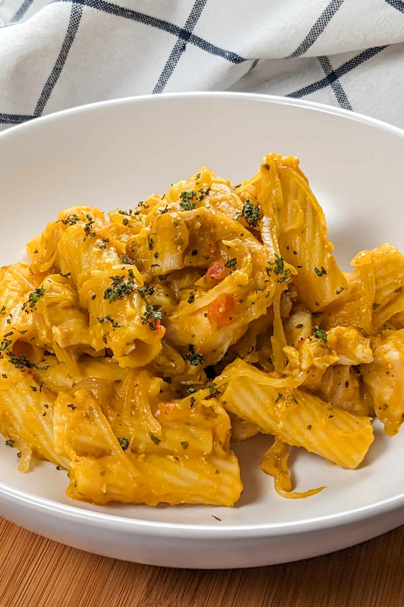 side view of the Creamy Cheesy Sage Chili Pumpkin Chicken Pasta on a wide round pasta bowl.