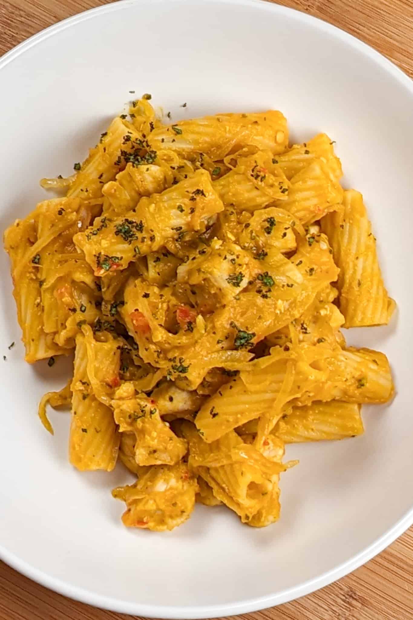 top view of the Creamy Cheesy Sage Chili Pumpkin Chicken Pasta in a round wide pasta bowl.