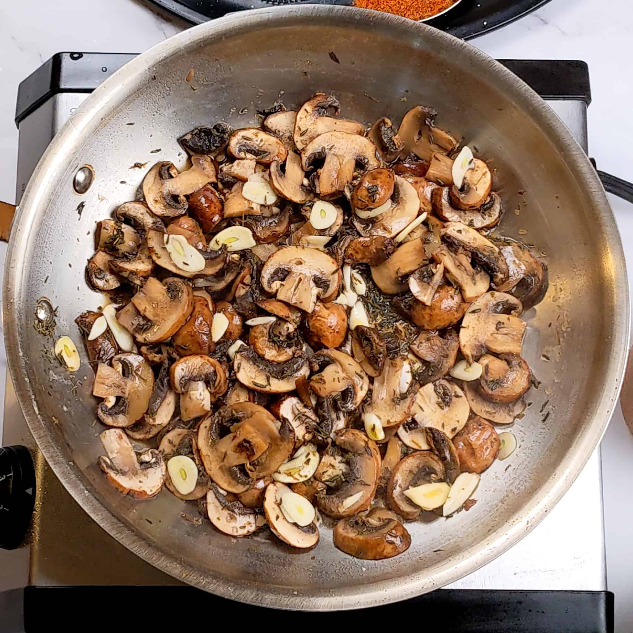 sauteed sliced mushrooms in an all-clad frying pan